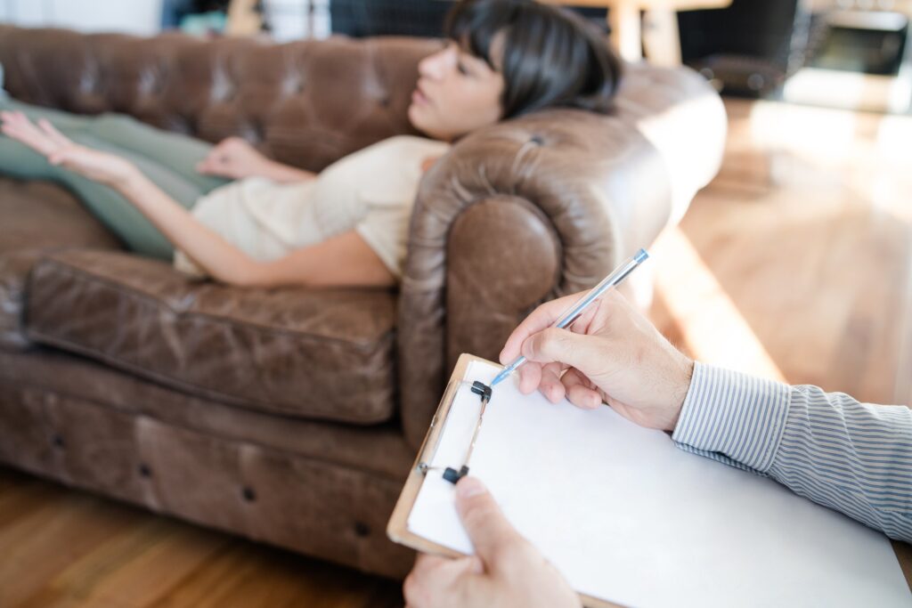 Psychologist taking notes during therapy session.