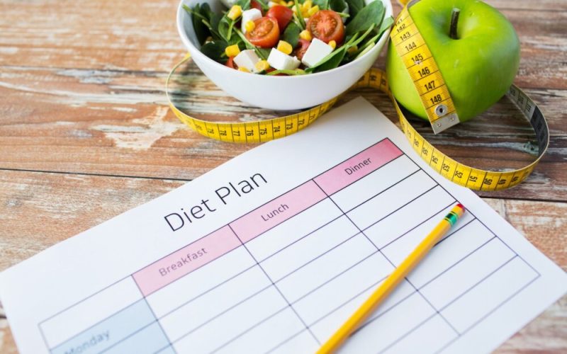 close up of diet plan and food on table